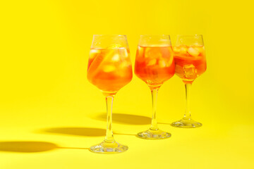 Glasses of Aperol spritz cocktail on color background