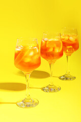 Glasses of Aperol spritz cocktail on color background