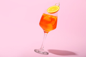 Glass of Aperol spritz cocktail on color background