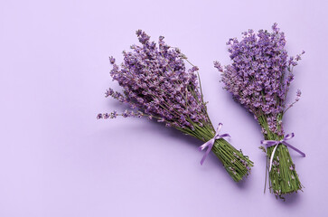 Bouquets of lavender flowers on color background