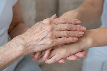 An elderly mother calms her daughter, strokes her, holds her hand in close-up