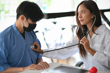 Female doctor checking patient body by stethoscope