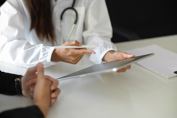 Doctor discussing health symptoms over digital tablet