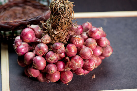 close-up view of bunch of red onions on black board