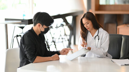 Generic female physician or doctor talking with her patient in office