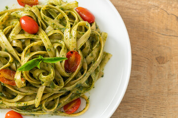 fettuccine spaghetti pasta with pesto sauce and tomatoes