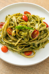 fettuccine spaghetti pasta with pesto sauce and tomatoes