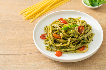 fettuccine spaghetti pasta with pesto sauce and tomatoes