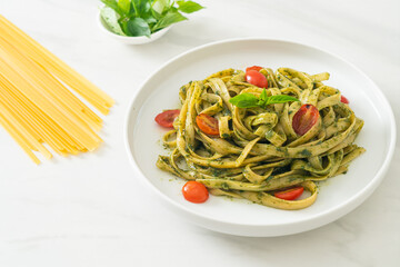 fettuccine spaghetti pasta with pesto sauce and tomatoes