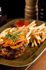 sliced aspic of beef tongue served with french fries on plate on a wooden table with mustard