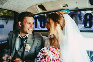 The bride and groom have fun in the limousine