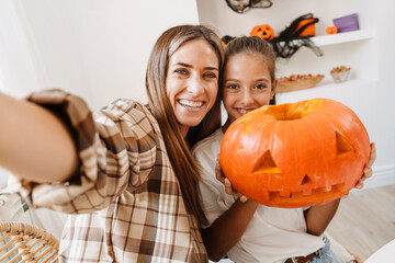 White mother and daughter taking selfie while getting ready for Halloween