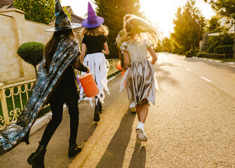 White children running down street during trick-or-treating © Drobot Dean