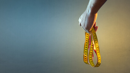 Hand holding a yellow tape measure