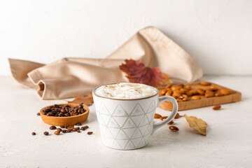 Cup of tasty almond latte on light background