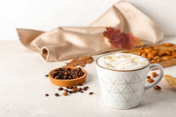 Cup of tasty almond latte on light background