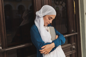 Young muslim girl wears hijab with diary book. Islamic student and knowledge concept.