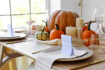 Beautiful autumn table setting with invitation in room