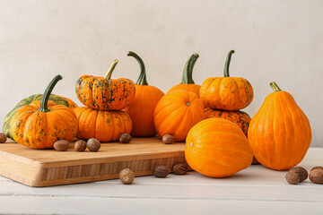 Composition with ripe pumpkins and nutmeg on light background