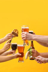 Hands with beer and snacks on color background