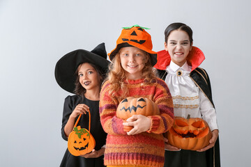 Cute little children in Halloween costumes on light background