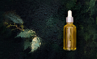 cosmetic serum bottle on natural background with water drops organic cosmetics