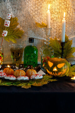 Example decorating themed buffet table with Halloween sweets in vertical photo format. Selection sweet appetizers, drink themed Halloween. Festive home Halloween themed food, decor. Party food table.
