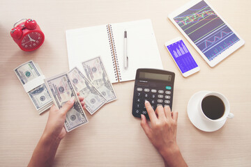 Close-up of female hands counting money, earnings or profits from stock market investments.