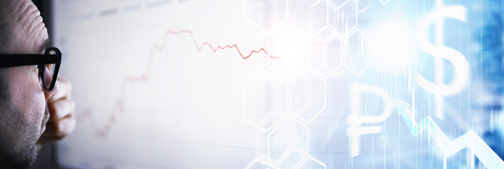 A businessman is looking at a graph on a monitor. An exchange broker evaluates stock market trends. A man with glasses in front of a curve of the dynamics of the economy.