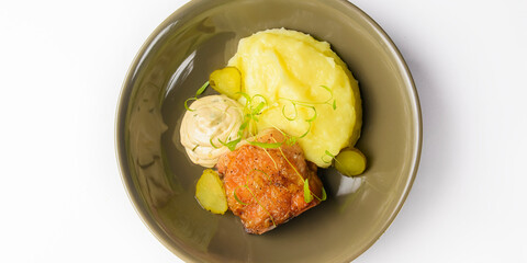 Spicy chicken served with mashed potatoes in a bowl over wite background.