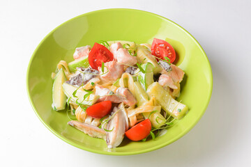 A plate of penne pasta with creamy sauce and a sprinkling of cheese with sliced cherry tomatoes