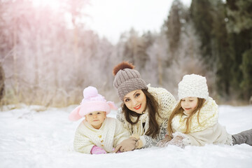 Happy family playing and laughing in winter outdoors in the snow. City park winter day.