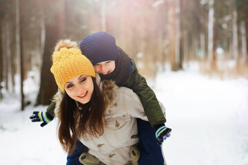 Happy family playing and laughing in winter outdoors in the snow. City park winter day.