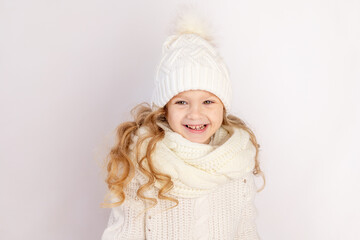 happy baby girl in warm hat and sweater on white isolated background, space for text