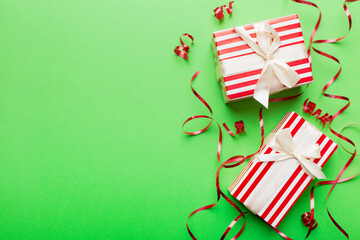 Holiday flat lay with gift boxes wrapped in colorful paper and tied decorated with confetti on colored background. Christmas, Birthday, Valentine and sale concept, top view