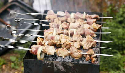 Marinated shashlik preparing on a barbecue grill over charcoal. Traditional Russian shashlik on a barbecue skewer