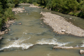 A stony river in the mountains on a warm sunny day