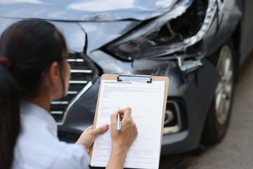Woman insurance agent fills out insurance form for car damage after traffic accident - obrazy, fototapety, plakaty