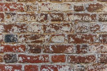 abstract background of an old shabby red brick wall painted yellow close up