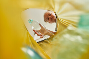 Girl throwing plastic bottle in garbage bag