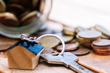 mortgage or real estate concept. keys, coins and house keychain