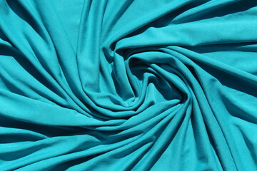 Turquoise jersey heavy crumpled fabric lies on the surface.