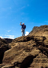 Hombre con mochila en el pico de los acantilados de la playa de Las Catedrales en Galicia
