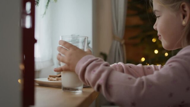 Little girl waiting for Santa Claus with cookies and milk. Shot with RED helium camera in 8K
