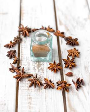 Star anise arranged around cumin powder in jar