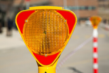 Close-up of a triangle-shaped flasher traffic warning light, which is positioned to ensure traffic...