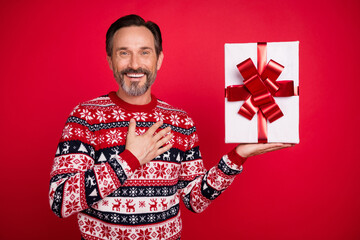 Photo portrait man in sweater thankful receiving gift box on winter holidays isolated vibrant red color background