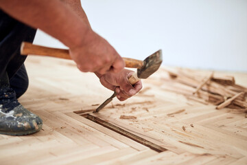 Repairman restoring old parquet hardwood floor.