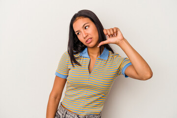 Young latin woman isolated on white background  showing a dislike gesture, thumbs down....