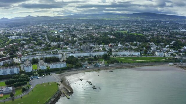 Monkstown, Dublin, Ireland, September 2021. Drone gradually tracks along the coastline while orbiting Monkstown Parish Church with Killiney hill and the Dublin mountains in the distance.